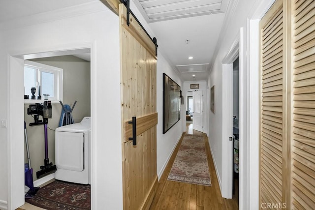 hallway with recessed lighting, wood finished floors, baseboards, attic access, and washer / clothes dryer