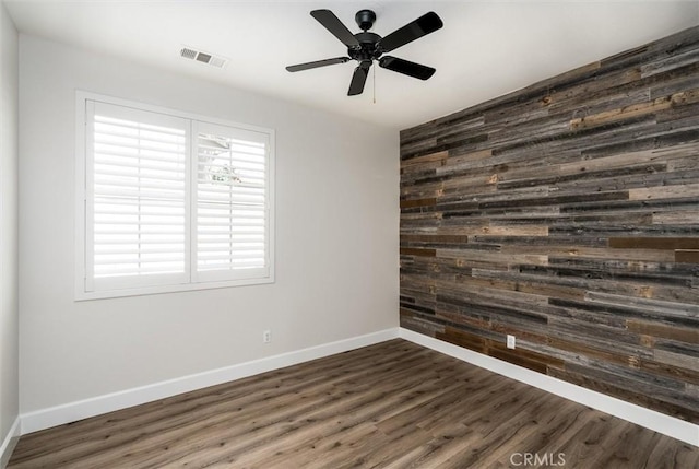 30461 Savoie St, Murrieta, CA 92563 - unfurnished room with dark wood-style flooring, baseboards, wood walls, and visible vents
