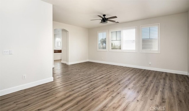 30461 Savoie St, Murrieta, CA 92563 - spare room with arched walkways, a ceiling fan, baseboards, and wood finished floors