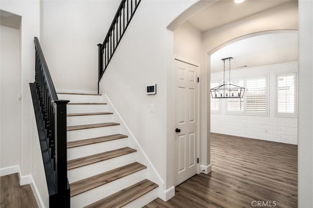30461 Savoie St, Murrieta, CA 92563 - stairway featuring arched walkways, baseboards, a chandelier, and wood finished floors