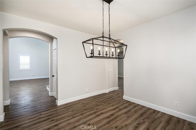 30461 Savoie St, Murrieta, CA 92563 - unfurnished dining area with arched walkways, baseboards, and dark wood-style flooring