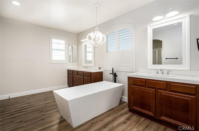 30461 Savoie St, Murrieta, CA 92563 - full bath with a notable chandelier, a sink, baseboards, two vanities, and wood finished floors