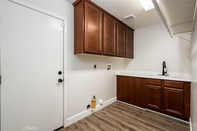 30461 Savoie St, Murrieta, CA 92563 - washroom with gas dryer hookup, cabinet space, wood finished floors, a sink, and hookup for a washing machine