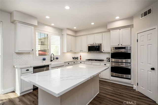 30461 Savoie St, Murrieta, CA 92563 - kitchen featuring visible vents, white cabinetry, a sink, appliances with stainless steel finishes, and backsplash