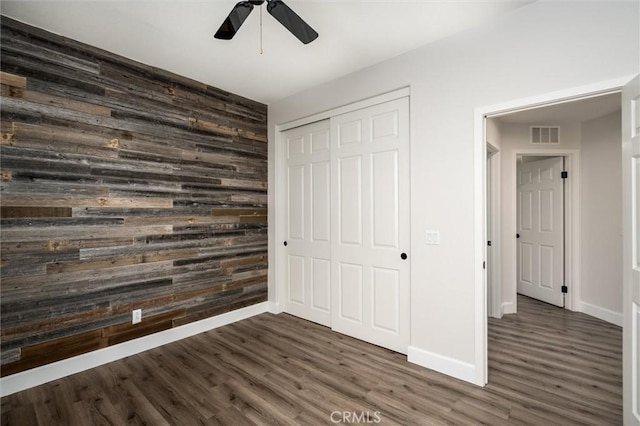 30461 Savoie St, Murrieta, CA 92563 - unfurnished bedroom with wooden walls, a closet, dark wood finished floors, and visible vents