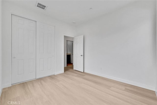 unfurnished bedroom with baseboards, visible vents, and light wood finished floors