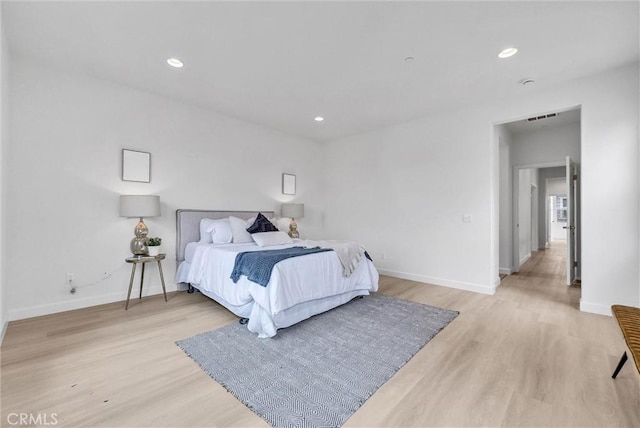 bedroom featuring baseboards, visible vents, and light wood-style flooring