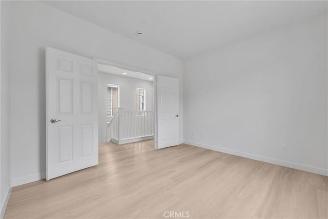 unfurnished bedroom with light wood-style flooring and baseboards