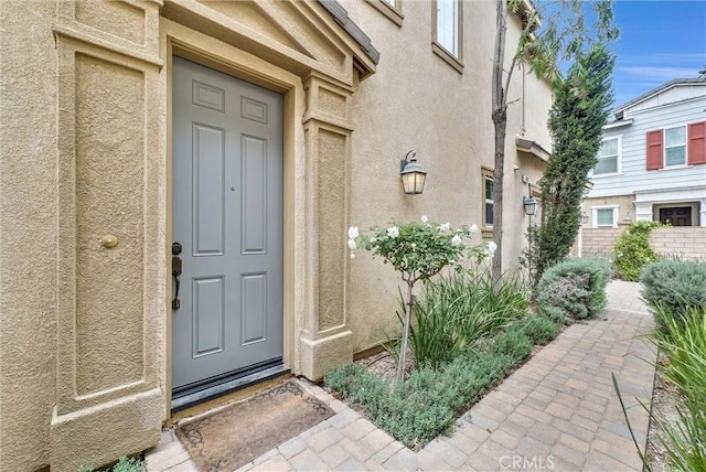 doorway to property featuring stucco siding