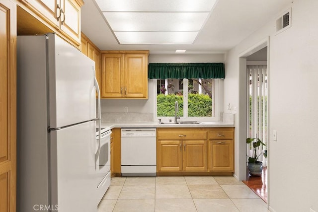 kitchen featuring a sink, white appliances, light tile patterned floors, light countertops, and visible vents