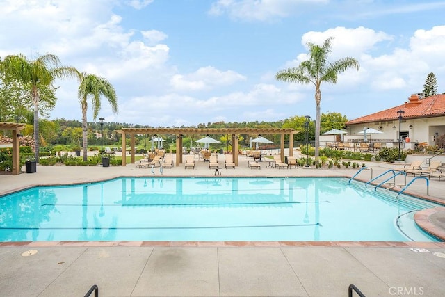 community pool with a pergola and a patio area