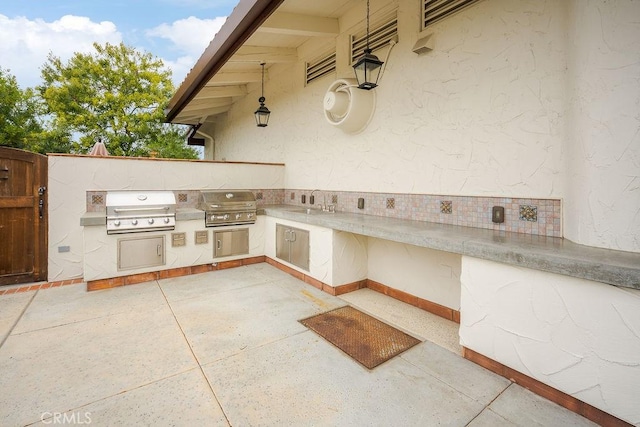 view of patio with grilling area, exterior kitchen, and a sink