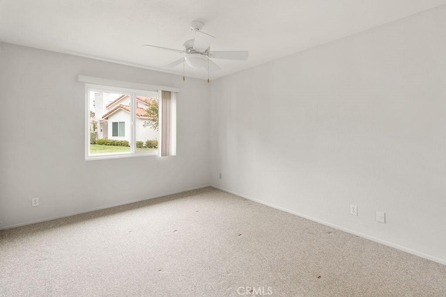 empty room featuring carpet flooring, baseboards, and ceiling fan
