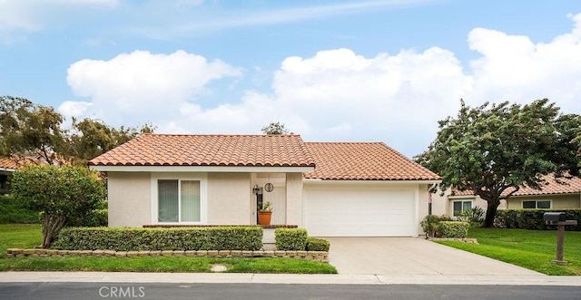 mediterranean / spanish-style home with stucco siding, an attached garage, driveway, and a tiled roof