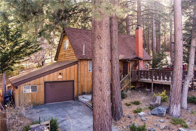 26704 Raven Rd, Wrightwood, CA 92397 - view of front of house featuring a chimney, roof with shingles, a deck, a garage, and aphalt driveway