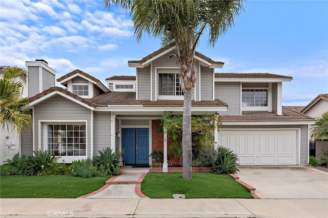 traditional-style home with concrete driveway, a chimney, a front lawn, and a garage