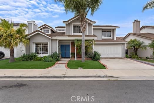 traditional-style home with driveway, a front lawn, and a garage