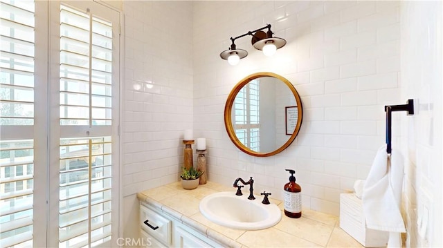 bathroom with decorative backsplash, a healthy amount of sunlight, and vanity