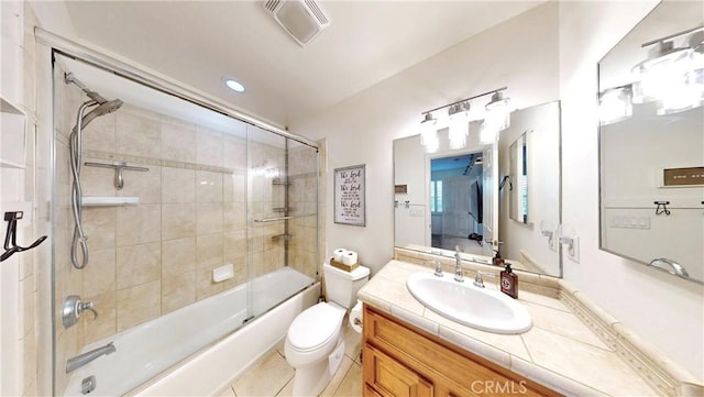 bathroom featuring combined bath / shower with glass door, vanity, toilet, tile patterned flooring, and visible vents