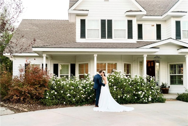 view of front of home with a shingled roof and covered porch