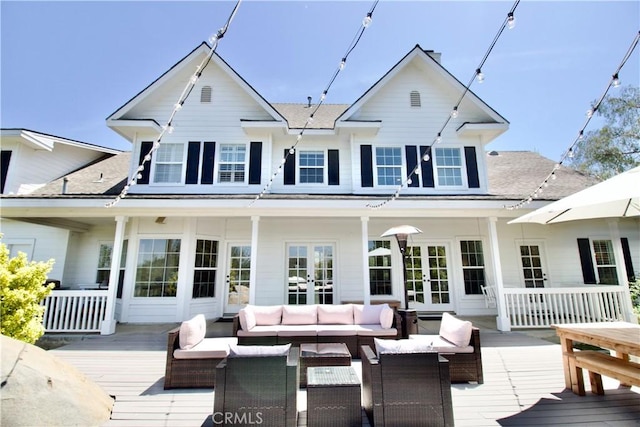 back of house featuring a wooden deck, outdoor lounge area, french doors, and roof with shingles
