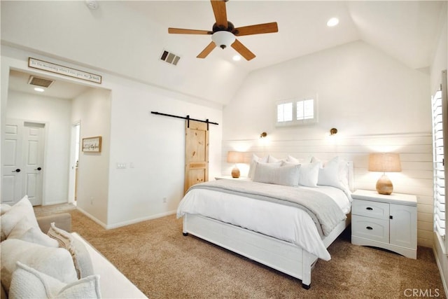 bedroom with a barn door, vaulted ceiling, visible vents, and light carpet