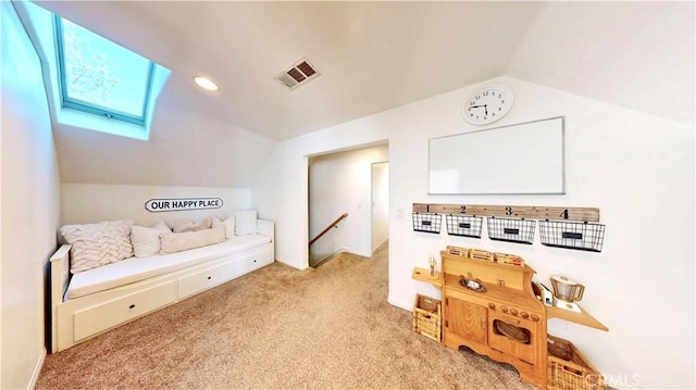 interior space featuring vaulted ceiling with skylight, visible vents, carpet flooring, and an upstairs landing