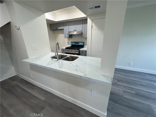 1709 Normandy Pl Unit B, Santa Ana, CA 92705 - kitchen featuring stainless steel range with gas stovetop, under cabinet range hood, gray cabinetry, dark wood finished floors, and light stone countertops