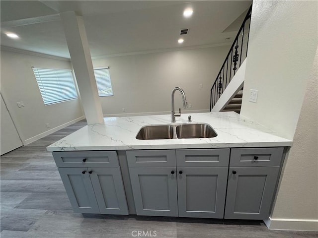 1709 Normandy Pl Unit B, Santa Ana, CA 92705 - kitchen featuring gray cabinetry, ornamental molding, light stone counters, and wood finished floors