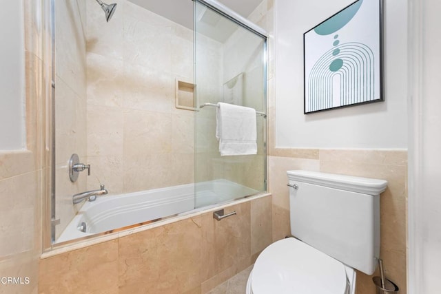 full bathroom featuring toilet, tiled shower / bath combo, and tile walls