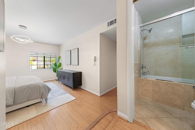 bedroom featuring baseboards, wood finished floors, and visible vents