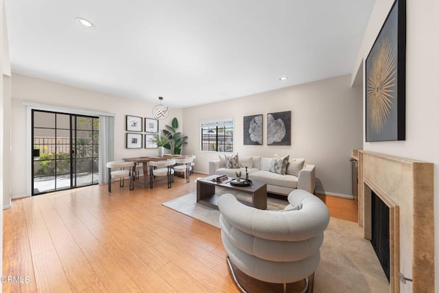 living area featuring light wood-type flooring, a fireplace, and recessed lighting