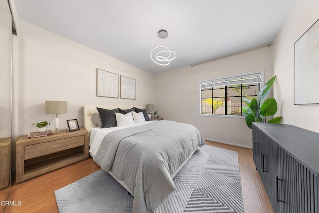 bedroom featuring light wood-style flooring and baseboards