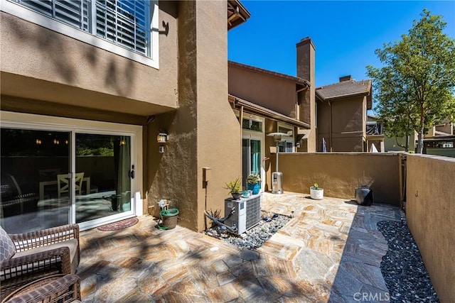 view of patio with central AC and fence