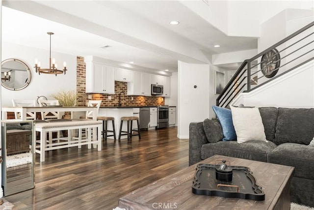 living room with stairs, dark wood-style floors, recessed lighting, and a chandelier