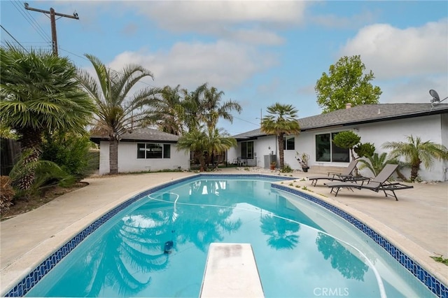 pool featuring a diving board and a patio