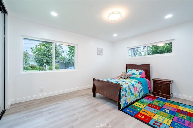 bedroom featuring baseboards, wood finished floors, and recessed lighting