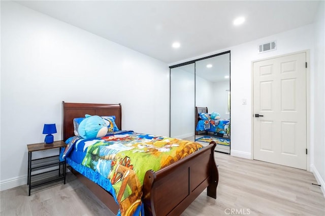 bedroom featuring baseboards, light wood-style floors, visible vents, and recessed lighting