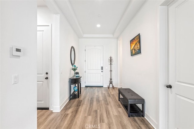 hallway with baseboards, recessed lighting, and light wood-style flooring