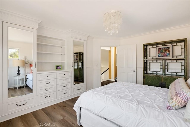bedroom featuring ornamental molding, a notable chandelier, and dark wood finished floors