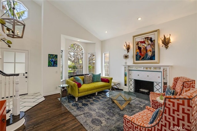 living room with baseboards, a tile fireplace, recessed lighting, dark wood-type flooring, and high vaulted ceiling