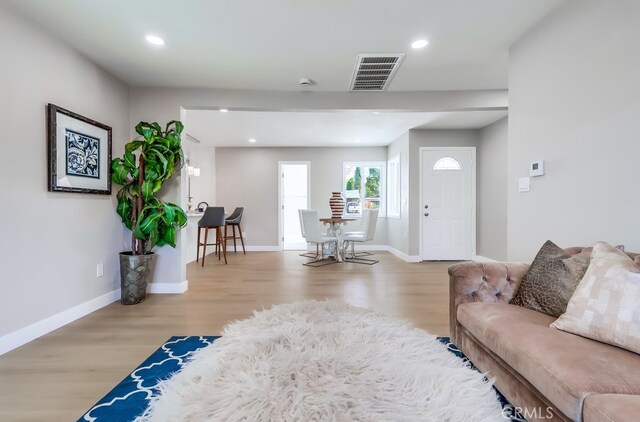 living area featuring wood finished floors, visible vents, and baseboards
