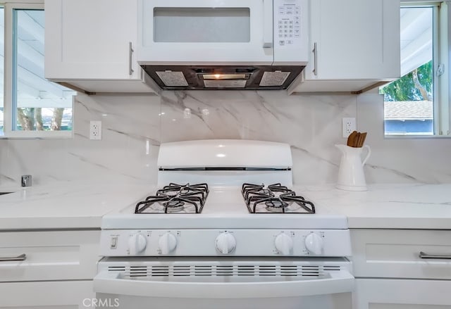 room details with white cabinetry, white appliances, and decorative backsplash