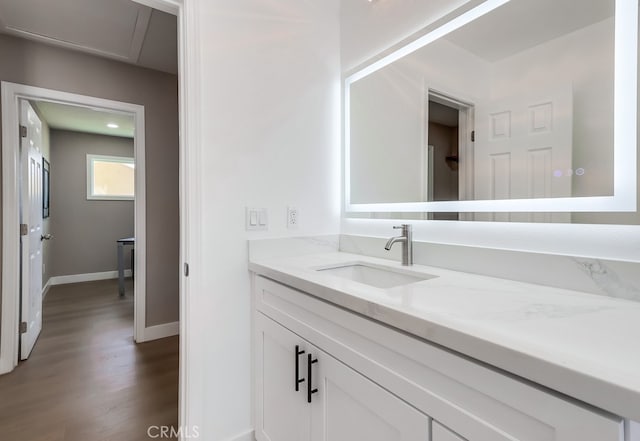 bathroom with baseboards, wood finished floors, and vanity