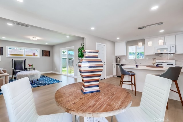 dining area with light wood-style flooring, visible vents, baseboards, recessed lighting, and track lighting
