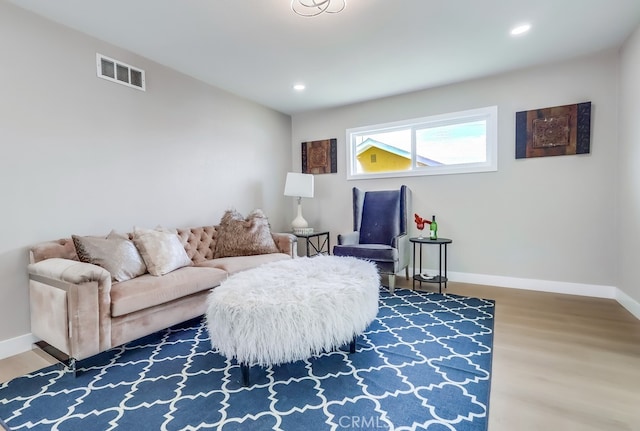 living area featuring visible vents, wood finished floors, and baseboards