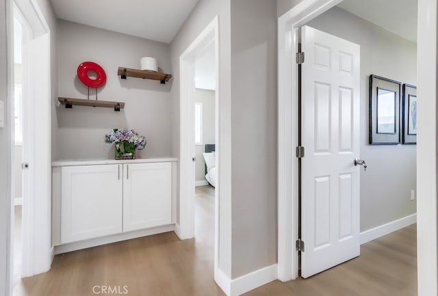 hallway with light wood finished floors and baseboards