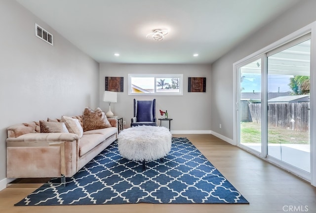 living room with wood finished floors, visible vents, recessed lighting, and baseboards