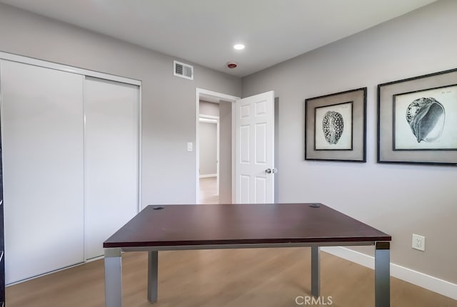 unfurnished office with recessed lighting, visible vents, wood finished floors, and baseboards