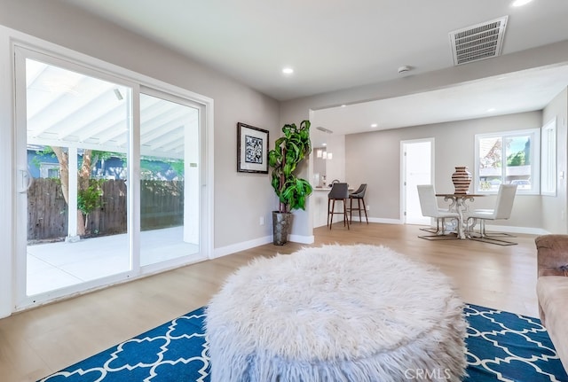 living area featuring recessed lighting, visible vents, wood finished floors, and baseboards